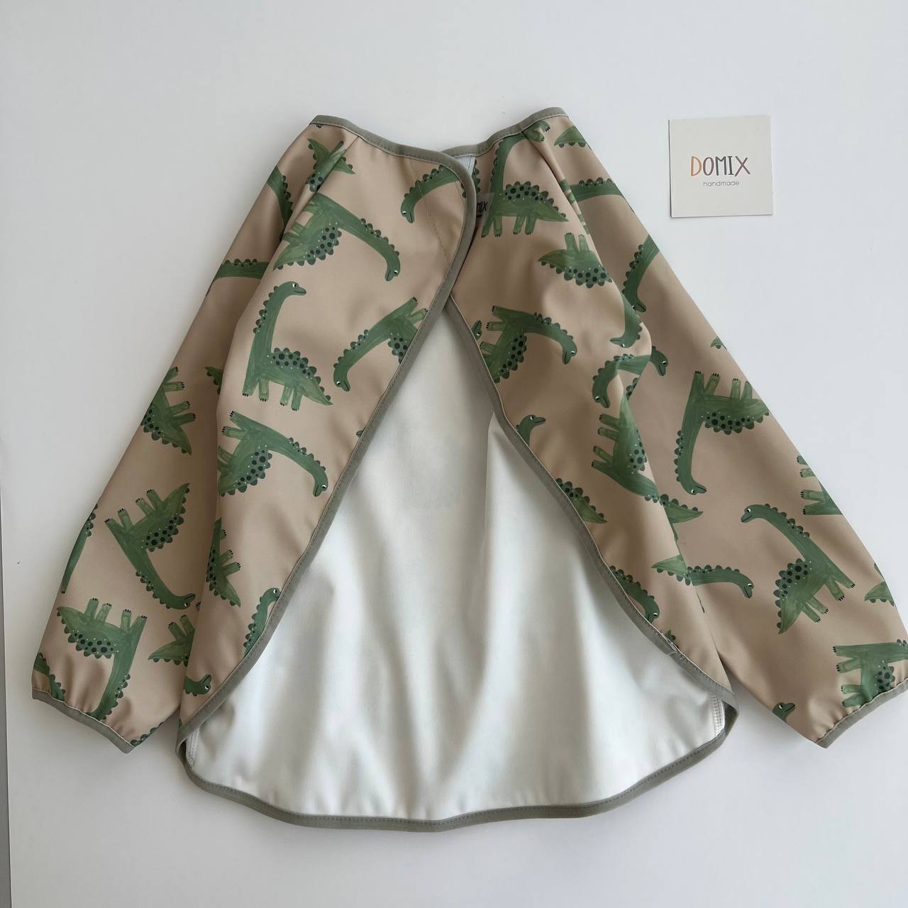 Children's raincoat with dinosaur pattern on a white background