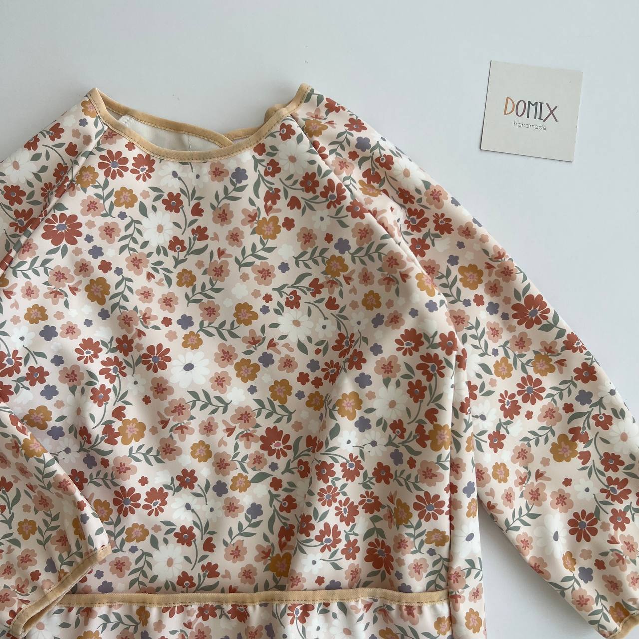 Floral-patterned dress on a white background with 'DOMIX' branding.